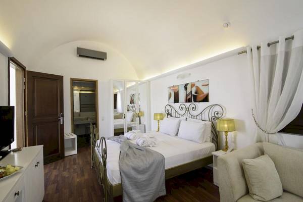 Schlafzimmer im La Mer Deluxe Hotel & Spa mit Doppelbett, Fernseher und Sofa.