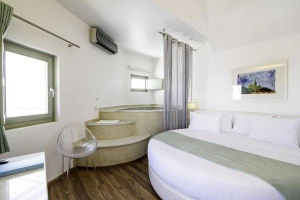 Innenansicht eines Zimmers im La Mer Deluxe Hotel & Spa mit Whirlpool, Bett und moderner Einrichtung.