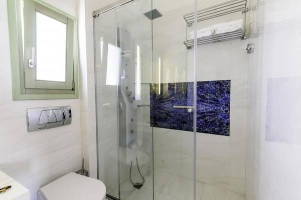Badezimmer im La Mer Deluxe Hotel & Spa mit Glasdusche und blauer Marmorwand.