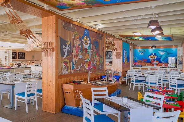 Innenansicht des Restaurants im H10 Suites Lanzarote Gardens Hotel mit bunten Wandmalereien und blauen Stühlen.