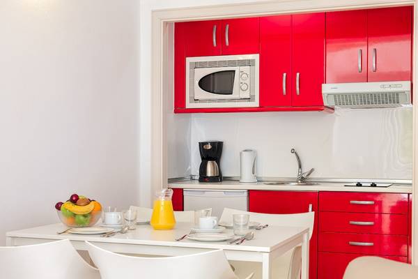 Kueche des H10 Suites Lanzarote Gardens Hotels mit roten Schranken und weisser Tischgarnitur.