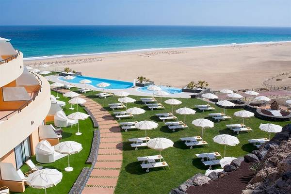 Aussicht auf die Pool-Area des Iberostar Playa Gaviotas Hotels mit vielen Sonnenschirmen und Liegen.