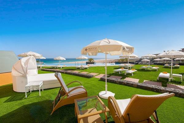 Loungebereich des Iberostar Playa Gaviotas Hotels mit Sonnenliegen, Schirmen und Meerblick.