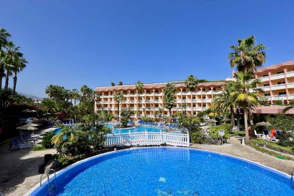 Außenansicht des Puerto Palace Hotels mit Swimmingpool und Sonnenliegen.