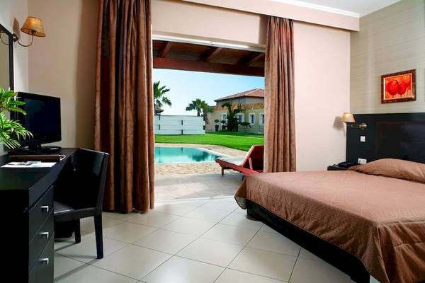 Ein Zimmer im Olympia Golden Beach Resort mit Blick auf den Pool von der Terrasse.