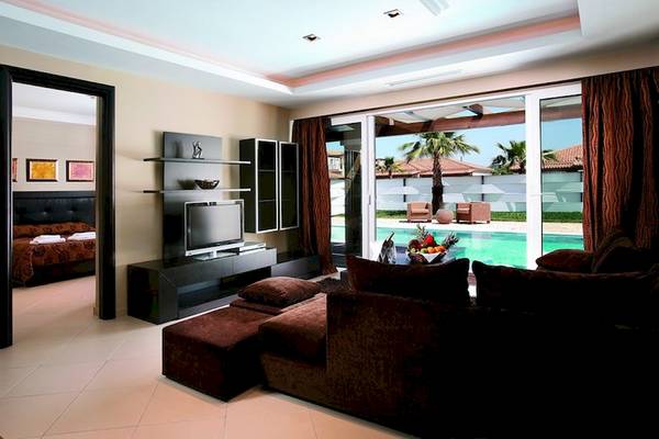 Wohnzimmer mit Ausblick auf den Pool im Olympia Golden Beach Resort.