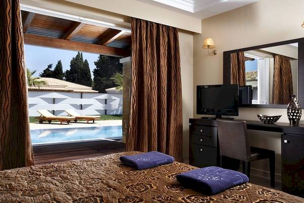Zimmer im Olympia Golden Beach Resort mit Blick auf den Pool und Garten