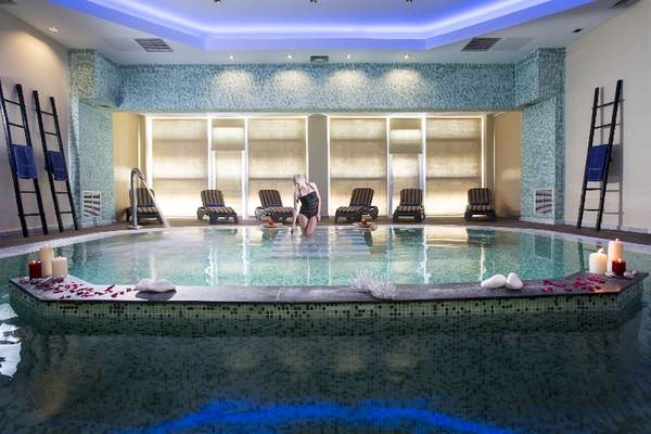 Spa-Pool im Olympia Golden Beach Resort mit einer Frau und Rosenblättern