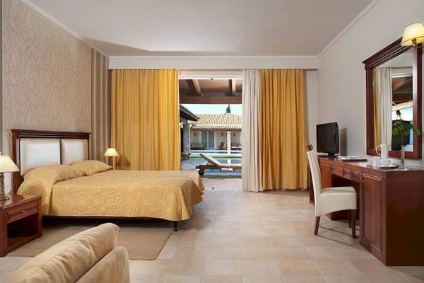 Doppelzimmer im Olympia Golden Beach Resort mit zwei Betten, Schreibtisch und Poolblick.