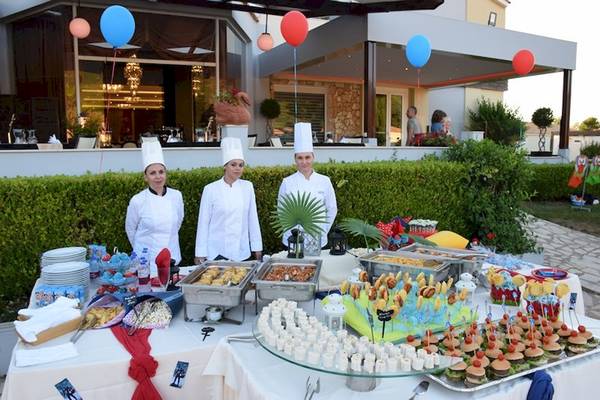 Drei Köche am Buffet im Olympia Golden Beach Resort mit vielen Speisen und Dekoration.