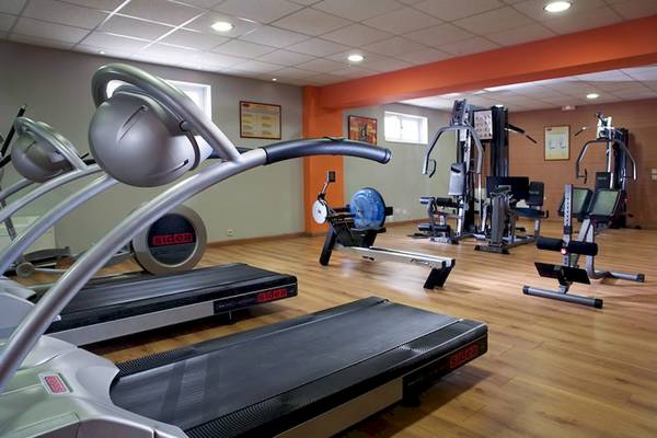 Fitnessraum im Olympia Golden Beach Resort mit Laufbändern und anderen Trainingsgeräten.
