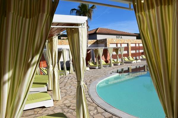 Spa-Bereich des Olympia Golden Beach Resorts mit grünen Liegestühlen und einem Pool.