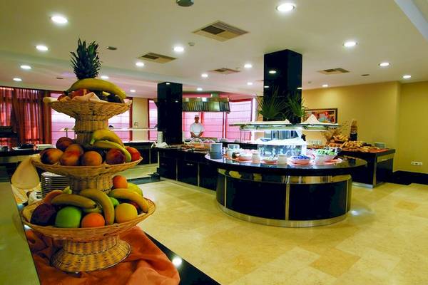Frühstücksbuffet im Olympia Golden Beach Resort mit verschiedenen Früchten und Speisen.