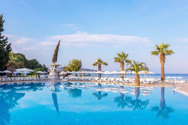 Poolbereich des Labranda TMT Bodrum Hotels mit weißen Sonnenliegen und Palmen.