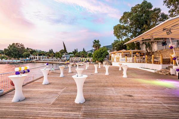 Terrasse des LABRANDA TMT Bodrum Hotels bei Sonnenuntergang mit weißen Tischen und bunten Luftballons.