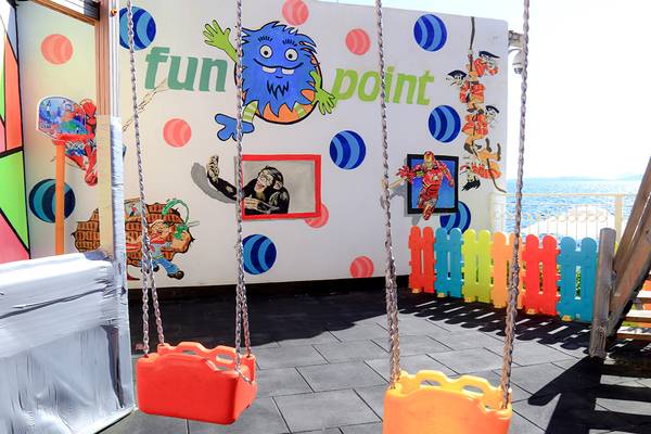 Spielplatz im LABRANDA TMT Bodrum Hotel mit bunten Schaukeln und einer Wandmalerei von einem Affen und einem Piraten.