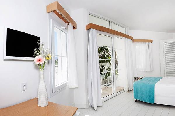 Innenansicht eines Zimmers im LABRANDA TMT Bodrum Hotel mit Bett, Fernseher und Balkonzugang