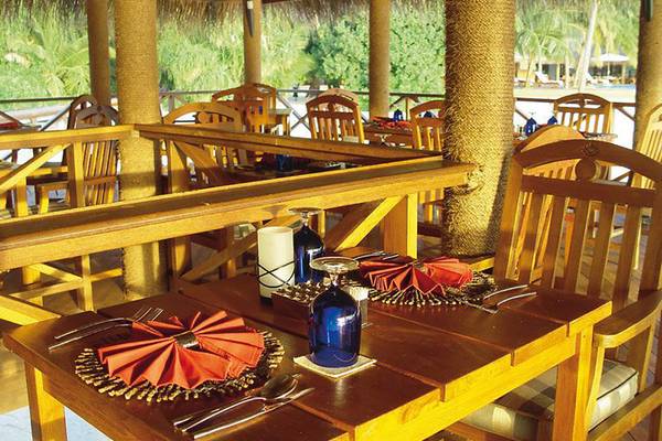Essen auf der Terrasse im Medhufushi Island Resort mit blauen Gläsern und roten Servietten.