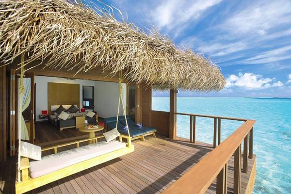Suite im Medhufushi Island Resort mit Blick auf das Meer und eine Hängematte auf der Terrasse.