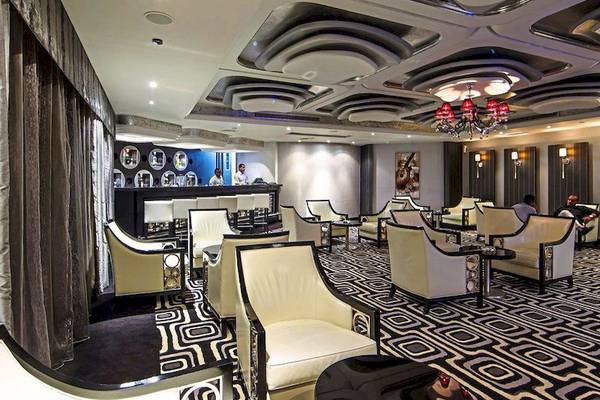 Bar-Lounge des KaiSol Romance Resorts in Sahl Hasheesh mit weißen Lederstühlen und schwarz-weißem Bodenmuster.