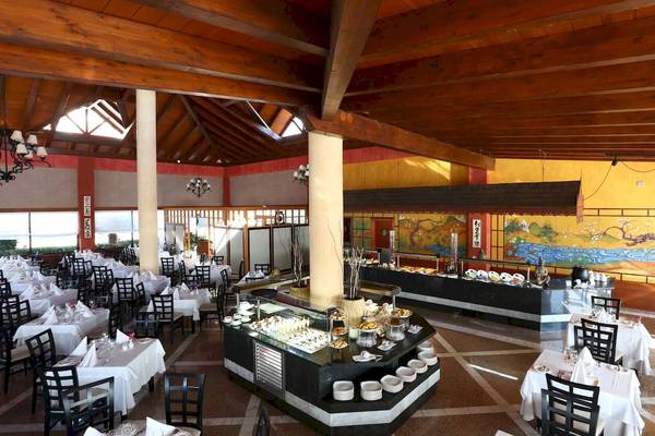 Restaurant im Hotel Bahia Principe Sunlight Costa Adeje mit Holzdecke und vielen Tischen.