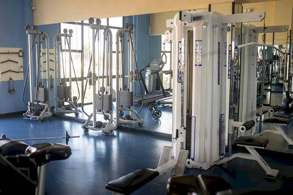 Fitnessstudio im Hotel Bahia Principe Sunlight Costa Adeje mit verschiedenen Trainingsgeräten und Spiegeln.