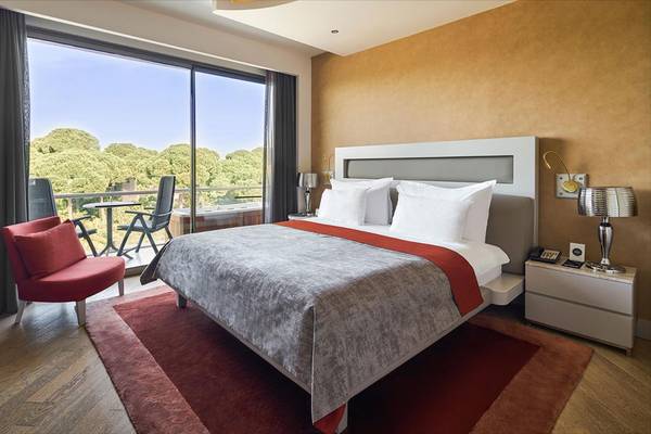 Zimmer im Maxx Royal Belek Golf Resort mit Bett, Balkon und Sicht auf Bäume