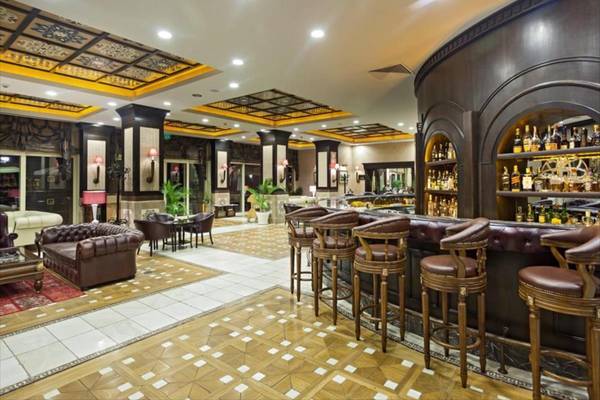 Lobby-Bar des Maxx Royal Belek Golf Resort Hotels mit Barhockern, Sitzgelegenheiten und Dekor.