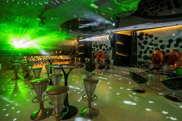 Discobereich im Maxx Royal Belek Golf Resort mit grünen Lichtern und modernen Stühlen.
