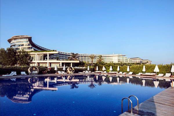Außenpool mit weißen Liegestühlen und Sonnenschirmen am Maxx Royal Belek Golf Resort.