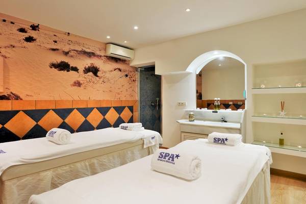 Spa-Behandlungsraum im Iberostar Malaga Playa Hotel mit zwei Behandlungsliegen und einem Wüstenwandbild.