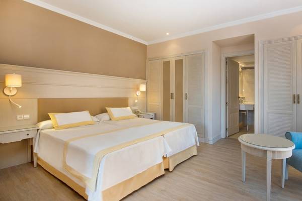 Doppelzimmer im Iberostar Malaga Playa Hotel mit zwei Betten, Nachttischen, Lampen und einem Badezimmer.
