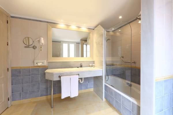 Badezimmer im Iberostar Malaga Playa Hotel mit Badewanne, Dusche und Waschbecken.
