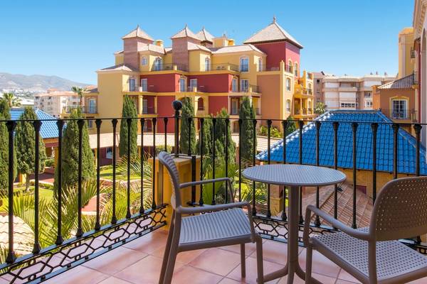 Balkon des Iberostar Malaga Playa Hotels mit Tisch und Stühlen.