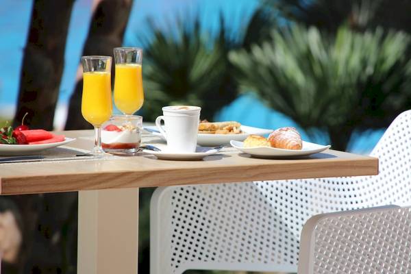 Frühstücksbuffet im Iberostar Malaga Playa Hotel mit Croissants, Orangensaft und Früchten.