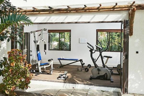 Fitnessraum im Recif Attitude Hotel mit Trainingsgeräten und einer offenen Tür.