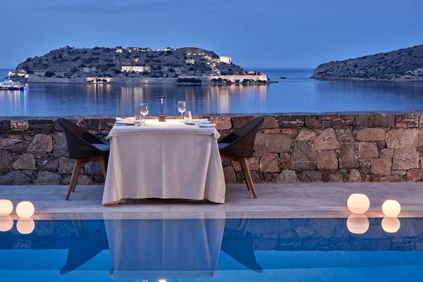 Esstisch am Pool mit Blick auf das Meer und eine Insel im Blue Palace Resort & Spa