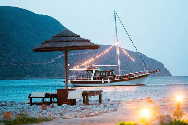 Boot am Strand bei Blue Palace Resort & Spa mit Berg im Hintergrund