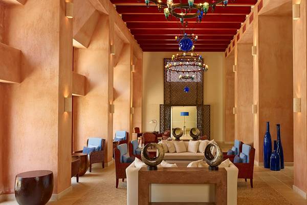 Lobby des Blue Palace Resort & Spa mit hellbraunen Wänden, einem großen zentralen Sofa und blauen Vasen.