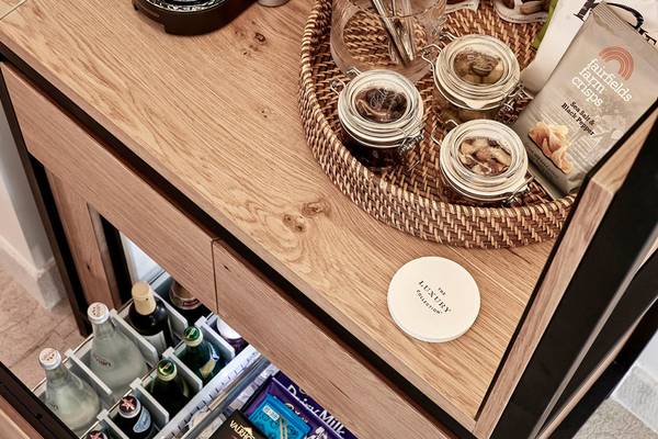 Minibar im Blue Palace Resort & Spa mit Getränken, Snacks und einem weißen Etikett.