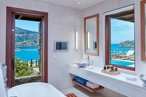 Badezimmer im Blue Palace Resort & Spa mit Panoramablick auf das Meer und die Berge.