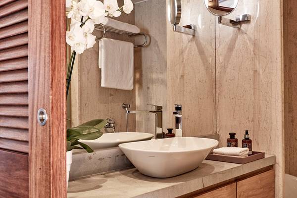 Ein Badezimmer im Blue Palace Resort & Spa mit Marmorwänden, einem Waschbecken und einer Badewanne.