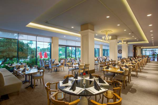 Innenansicht des Restaurants des IC Santai Family Resort mit gedeckten Tischen und Stühlen.