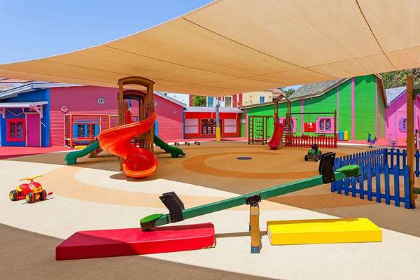 Spielplatz im IC Santai Family Resort mit bunten Häusern, Rutschen und Schaukeln.