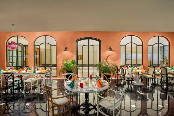 Innenbereich des Restaurants im IC Santai Family Resort mit Tischen, Stühlen und Pflanzen.
