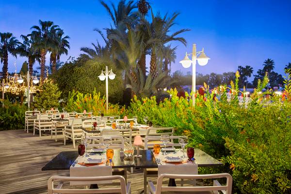 Außenrestaurant des IC Santai Family Resort bei Nacht mit illuminierten Bäumen und gedeckten Tischen.