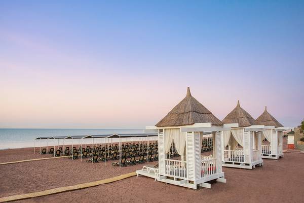 Strand mit Sonnenliegen und Pavillons im IC Santai Family Resort