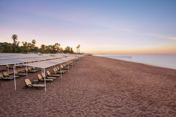 Strand des IC Santai Family Resort mit Sonnenliegen und Sonnenschirmen