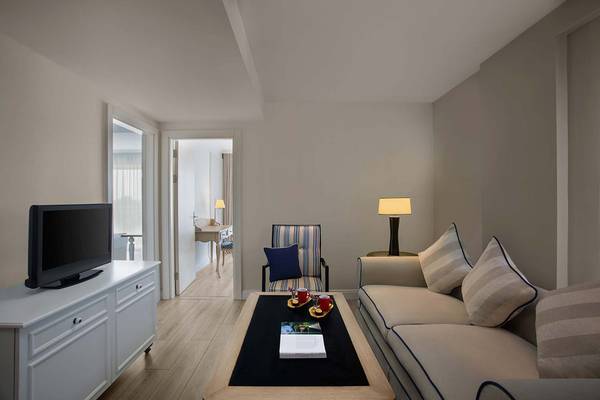Wohnbereich des IC Santai Family Resort mit Fernseher, Sofa, Tisch und Lampe.