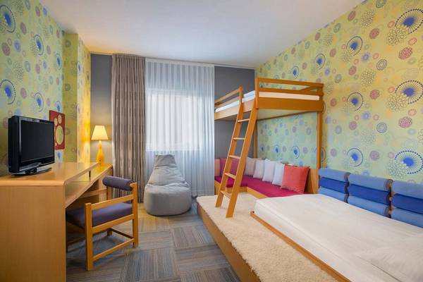 Schlafzimmer im IC Santai Family Resort mit Doppelstockbett, Fernseher, Schreibtisch und Sessel